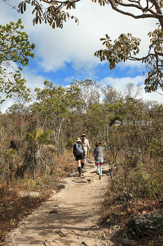 母亲和女儿走在Chapada dos Veadeiros国家公园肮脏的小路上，Goiás，巴西。